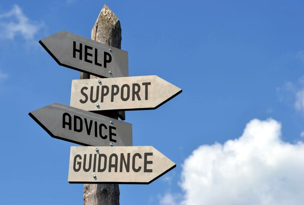 Signpost with directions for help, support, advice, and guidance against a blue sky.