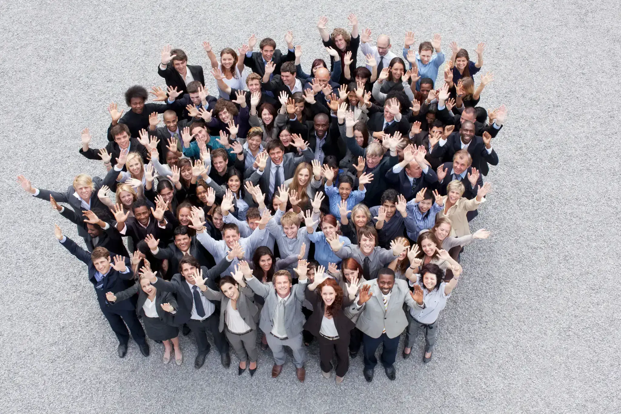 A large group of diverse people smiling and pointing at the camera.
