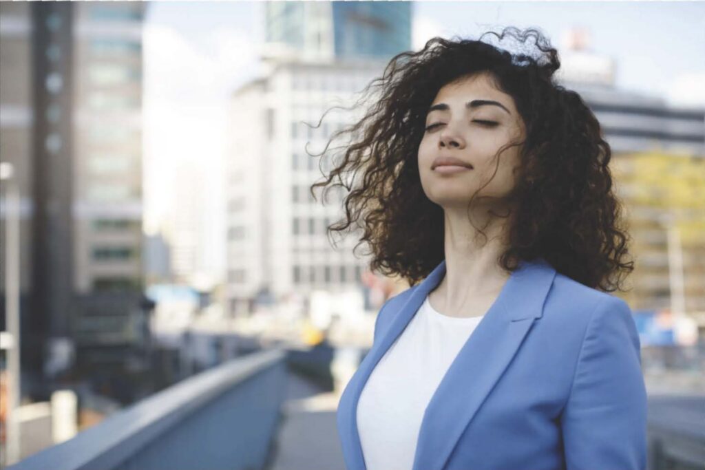 Woman enjoying fresh air in cityscape.