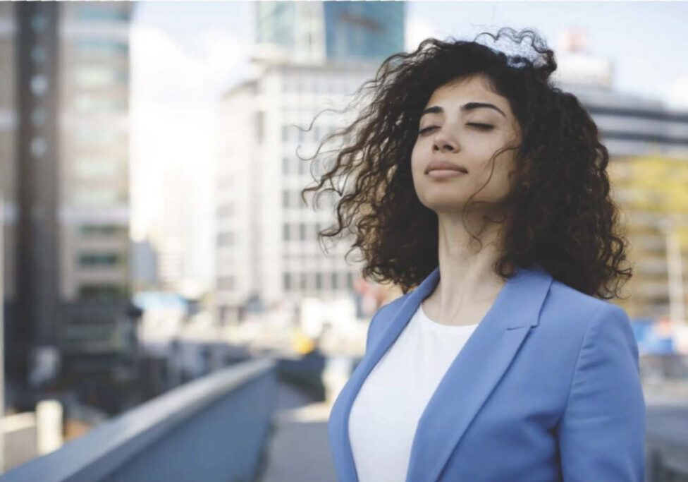 Woman enjoying fresh air in cityscape.